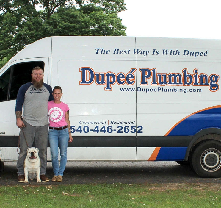 Eric and Jeannie Dupee stand proudly in front of a company truck